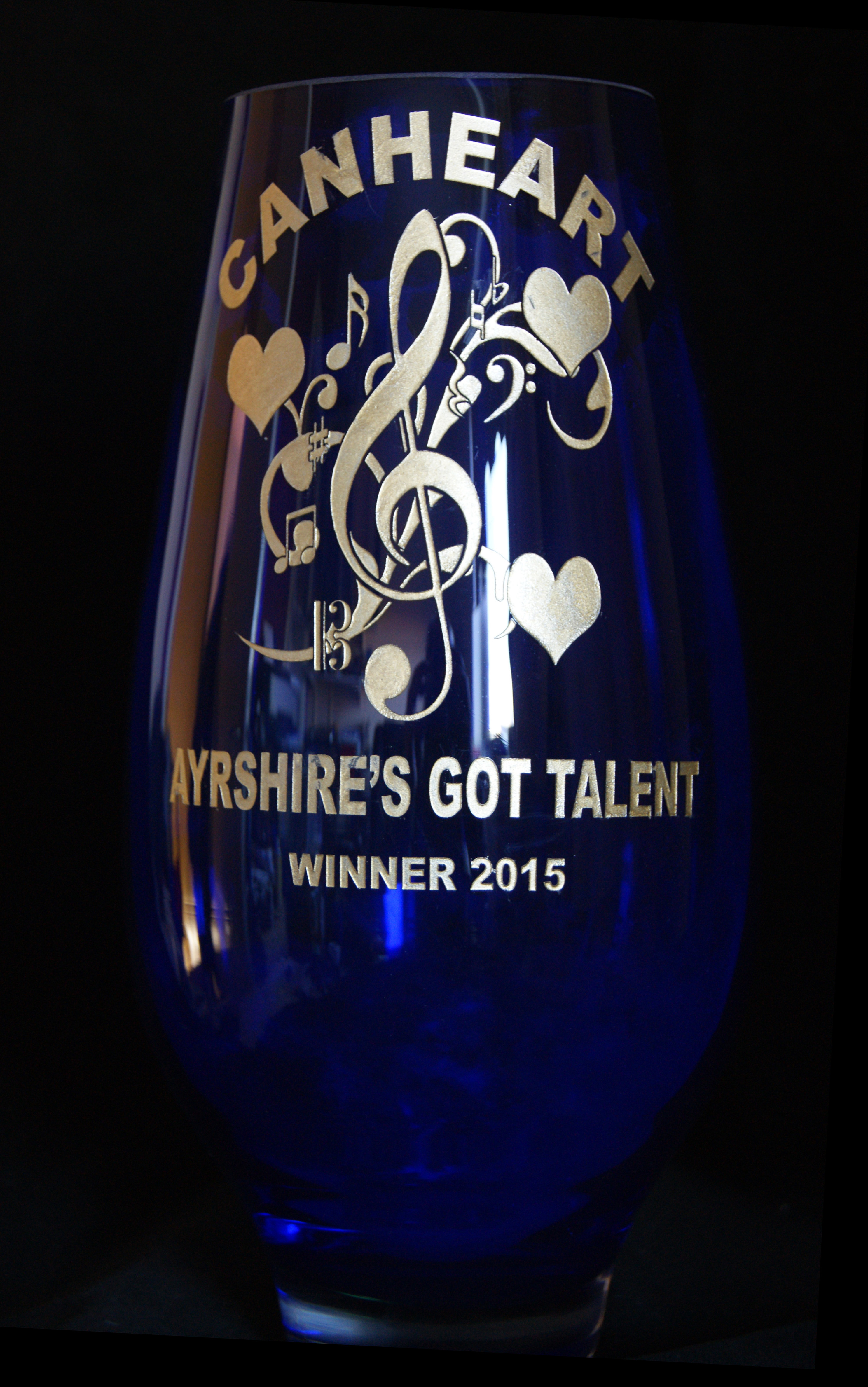 A deep blue vase with the CANHEART logo and Ayrshire's Got Talent engraved then infilled with gold