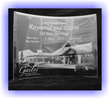 This is the photograph of a piece of Curved Glass. It is engraves with the picture of a wedding venue, the date of the wedding and the details of the wedding party 