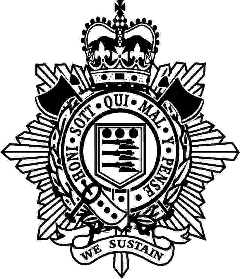 The Royal Logistic Corps artwork is made up of in the middle a shield containing three cannons and three cannon balls above. This is inside a belt circle with the words Honi Sott Qui Mal Y Pense on it. Surrounding this is a laurel wreath and crossed axes. These a on top of a star burst and has a royal crown on top.